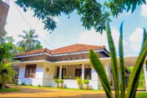 a white house with a red roof at Niwahana Transit City Hotel in Katunayaka