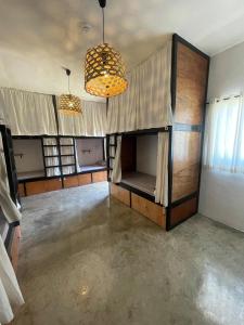 een lege kamer met 2 kroonluchters en een kamer met een bank bij MAAYONG HOSTEL in Moalboal