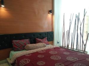 een slaapkamer met een groot bed en een rode deken bij Suburdi Guest House in Mujur