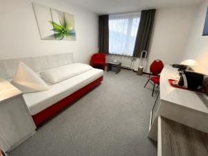 Habitación de hotel con cama y escritorio en Brenner Hotel, en Bielefeld