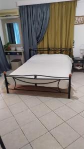 a bed in a bedroom with a tiled floor at Artemis GreenHill in Vravrona
