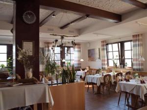 uma sala de jantar com mesas e cadeiras e um relógio em Landgasthof Zum Jossatal em Bad Soden-Salmünster