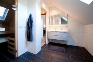 a bathroom with a sink and a toilet and a mirror at B&B De Drentse Es in Emmen