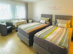1 Schlafzimmer mit 2 Betten und einem Stuhl in der Unterkunft Landgasthof Zum Jossatal in Bad Soden-Salmünster