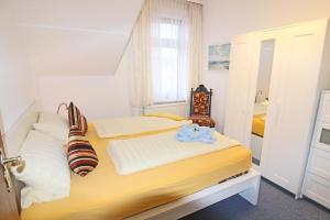 Kapitaenshaus-Lassen-Zimmer-Odysseus في فيسترلاند: غرفة نوم بها سرير بملاءات بيضاء ونافذة