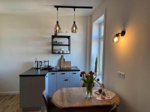 Kapitaenshaus-Lassen-Zimmer-Odysseus في فيسترلاند: مطبخ مع طاولة خشبية ومطبخ مع حوض +5 صور