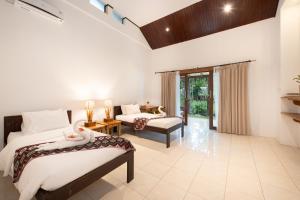 a bedroom with two beds and a living room at Murex Dive Resort in Manado