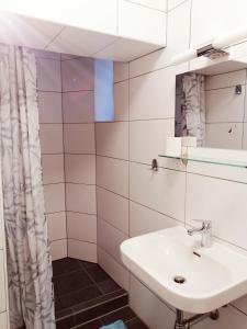 W łazience znajduje się umywalka i lustro. w obiekcie Apartmenthaus beim LKH Graz w Grazu