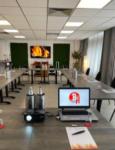 a conference room with a laptop computer on a table at Brenner Hotel in Bielefeld