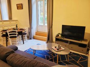 a living room with a couch and a tv and a table at St Nectaire- Appartement Terrasse Privée- 4 personnes in Saint-Nectaire