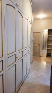 Habitación con puertas blancas en el armario y pasillo. en St Nectaire- Appartement Terrasse Privée- 4 personnes en Saint-Nectaire