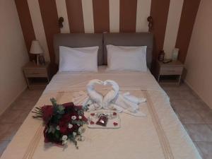 a bed with a bouquet of flowers and wedding items at Marinos Studios at Lourdata village in Lourdata
