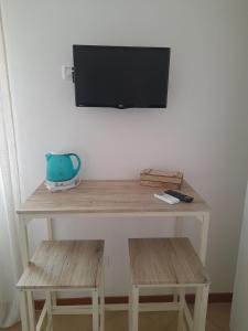a wooden table with a tv on a wall at La dimora felice in Marmi