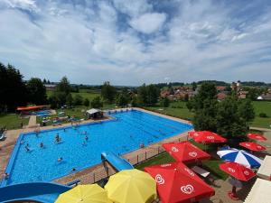 einen Blick über einen Pool mit Sonnenschirmen in der Unterkunft Ferienwohnung Engelhardt in Oberreute