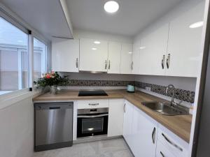 a kitchen with white cabinets and a sink at Fuengirola Center in Fuengirola