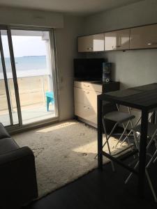 uma sala de estar com uma mesa e vista para a praia em Superbe vue mer Pornichet, au 5e + parking couvert em Pornichet