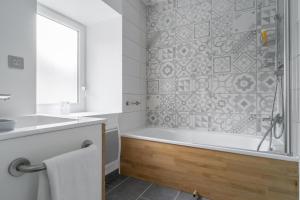 ein Badezimmer mit Badewanne, Waschbecken und Dusche in der Unterkunft Gîtes L'Escargot Bleu in Oloron-Sainte-Marie + 52 Fotos