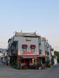 a large white building with a restaurant in front of it at Rebetika Hotel & bistro in Selçuk