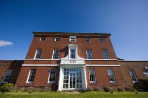 ein großes rotes Backsteingebäude mit einem großen Fenster in der Unterkunft Kedleston Country House B&B in Derby