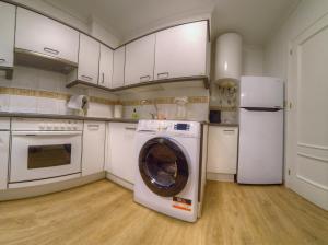 uma cozinha com uma máquina de lavar roupa e um frigorífico em Vistamar. Primera línea. Bahía de Santoña em Santoña
