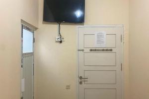 a door with a television on the wall next to it at CK Homestay Syariah near Lippo Plaza Jambi Mitra RedDoorz in Paalmerah +6 photos