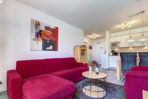 ein Wohnzimmer mit einem roten Sofa und einem Tisch in der Unterkunft Residenz am Balmer See - BS 48 mit Wellnessbereich in Balm