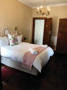 a bedroom with a large bed with two towels on it at Beesdam Guesthouse in Potchefstroom
