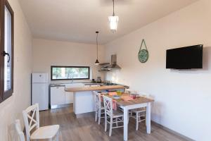 a kitchen with a table with chairs and a television at STELLA MARINA B&B in Alliste