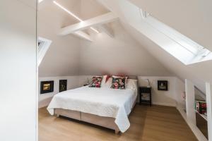 una camera bianca con un letto in mansarda di Appartement HIMMEL & Höllerl a Fürstenfeld