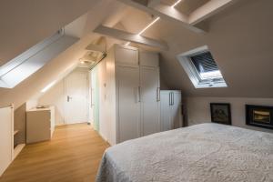 - une chambre avec un lit et un plafond avec des lucarnes dans l'établissement Appartement HIMMEL & Höllerl, à Fürstenfeld