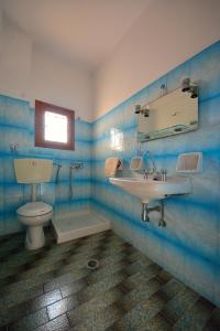 a bathroom with a sink and a toilet and a mirror at Studios Calvinos in Marathokampos