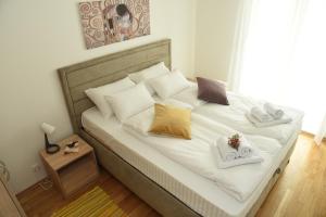a bedroom with a bed with two towels on it at Suncokret Apartmani Loznica in Loznica