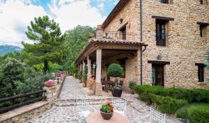 Casa de piedra con balcón y patio en Hotel de Montaña Cueva Ahumada, en Villaverde de Guadalimar