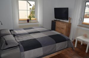 Oberkotzau的住宿－Fewo Bauer，一间卧室配有一张床和一台平面电视