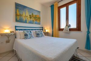a bedroom with a bed and a painting on the wall at Sardinia Re - Casa Ginestra in Stintino
