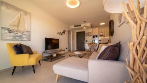 a living room with a white couch and yellow chairs at Romantic Villa Helidoni in Svoronata