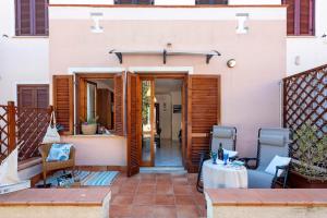 a house with a patio with a table and chairs at Sardinia Re - Casa Ginestra in Stintino