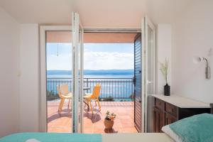 a bedroom with a balcony with a table and chairs at Mirabilis - Private Beach House in Lokva Rogoznica