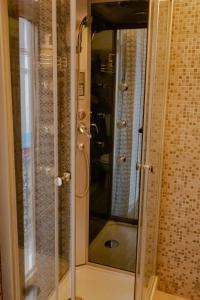 W łazience znajduje się prysznic ze szklanymi drzwiami. w obiekcie Passaggio a Sud Ovest w mieście Iglesias