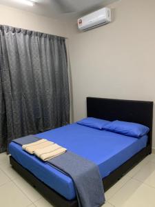 a bedroom with a bed with blue sheets and a window at LA 1 Homestay Putrajaya Dwiputra in Putrajaya