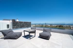 a patio with two chairs and a table on a roof at Karat Suites in Vóthon
