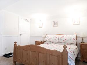 una camera con letto in legno e pareti bianche di The Willow Bed and Breakfast a Pateley Bridge