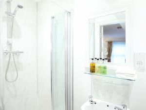 a white bathroom with a shower and a sink at The Willow Bed and Breakfast in Pateley Bridge