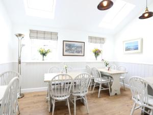 a white dining room with a table and chairs at The Willow Restaurant B&B in Pateley Bridge