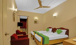 a hotel room with a bed and a chair at Treebo Trend Mira Inn in Kolkata