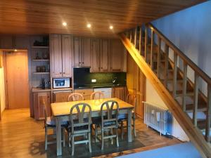 una cocina con mesa y sillas y una escalera en Apartamento ideal para familias en la Molina, en La Molina