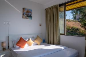 a bedroom with two beds and a large window at West Valley Villa 3BHK B in Mahabaleshwar