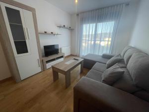 uma sala de estar com um sofá e uma mesa em Grupo Gontad Apartamento Villa Amparo Laxe em La Coruña