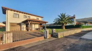 a house with a fence in front of a driveway at Villa Vacacional Villahormes in Naves