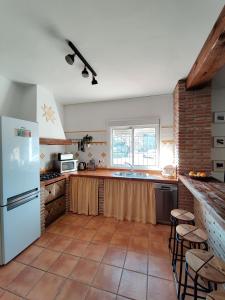 a kitchen with a white refrigerator and a tile floor at Casa Gala - Caminito del Rey in Málaga